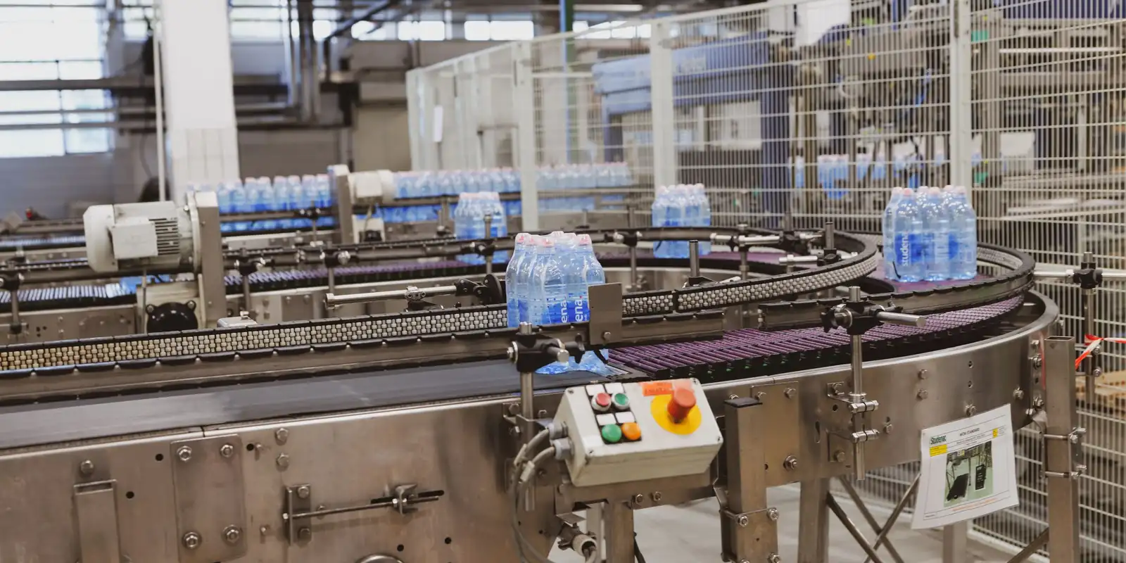 Butelki na taśmie produkcyjnej w hali rozlewni